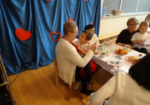 dziadkowie siedzą z wnuczętami przy stole