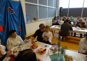 dziadkowie siedzą z wnuczętami przy stole