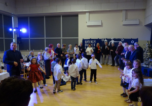 Dziadkowie tańczą w kółeczku, dzieci w środku