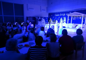 Dzieci podczas przedstawienia, dziadkowie robią zdjęcia, oglądają