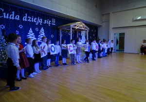 Dzieci mówią wierszyki dla dziadków, niektóre dzieci trzymają litery układające się w napis kochamy was