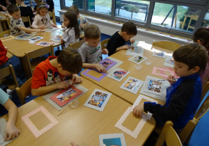 Dzieci naklejają ramki na tekturki ze zdjęciem