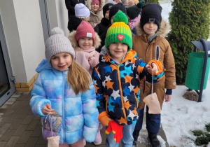 Dzieci pokazują słoninkę zawieszona na sznureczku