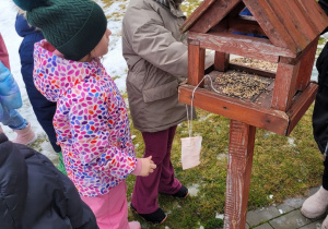 Dzieci sypia ziarno do karmnika