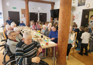 Dzieci wręczają laurki seniorom