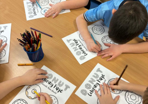 Dzieci kolorują karty pracy