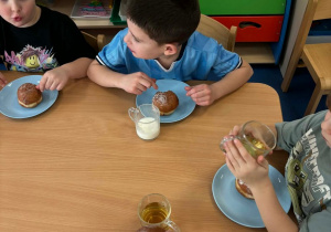 Dzieci jedzą pączki