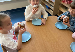 Dzieci jedzą pączki