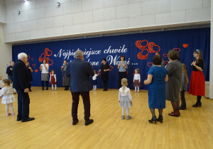 Uczestnicy spotkania stoją w kręgu podczas wspólnej aktywności.