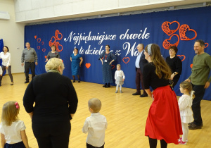 Uczestnicy stoją w kręgu podczas wspólnej zabawy.