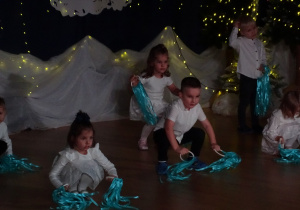 Dzieci kucają podczas układu tanecznego.