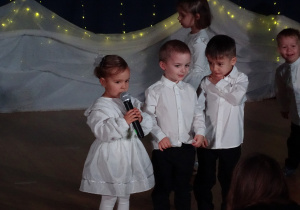 Dziewczynka mówi do mikrofonu.