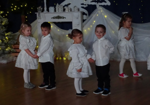 Dzieci stoją parami na scenie.