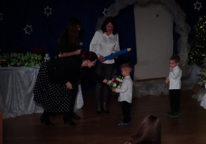 Nauczycielki wręczają dziecku upominek.