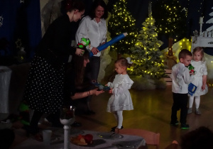 Nauczycielki przekazują dziecku pamiątkę.