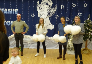 Dorośli stoją z pomponami podczas zabawy.