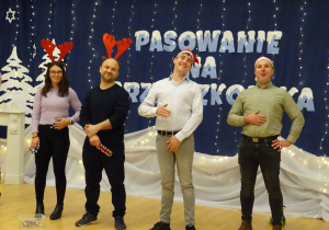 Dorośli stoją na scenie podczas występu.