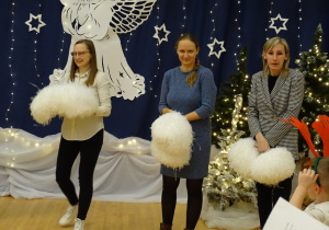 Rodzice trzymają pompony na scenie.