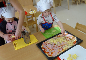 Dzieci ścierają na tarce ser
