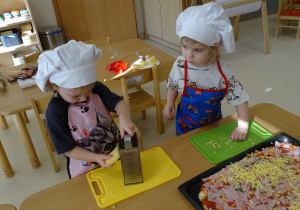 Dzieci ścierają na tarce ser