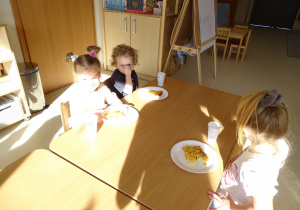 Dzieci jedzą pizzę