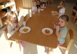 Dzieci jedzą pizzę