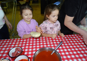 Dzieci trzymają ciasto na pizze