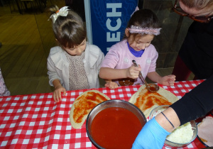 Dzieci smarują pizze sosem