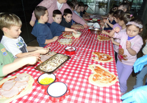 Dzieci układają ulubione dodatki na pizze