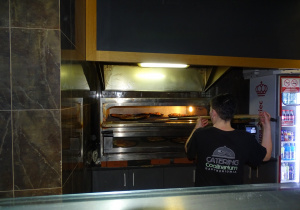 Pani wkłada pizze do pieca