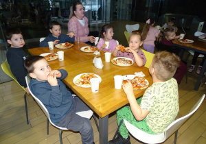 Dzieci zajadają sie pizzą