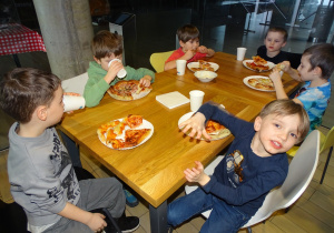 Dzieci zajadają sie pizzą