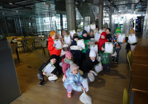 Zdjęcie grupowe dzieci przed pizzerią z dyplomami