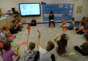 dzieci podczas quizu wiedzy, podnoszą kartonik z napisem nie