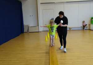 dziewczynka przechodzi po ławce