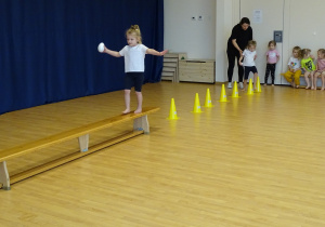 dziewczynka przechodzi po ławce