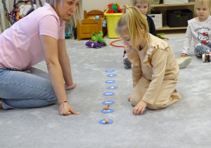 dziecko ustawia dinozaura według określonego kierunku