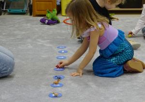 dziecko ustawia dinozaura według określonego kierunku