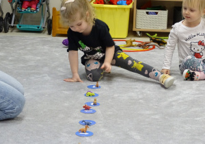 dziecko ustawia dinozaura według określonego kierunku