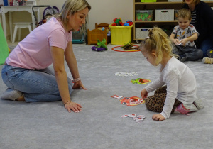 dzieci wkładają do buzi dinozaura odpowiednią ilość pokarmu