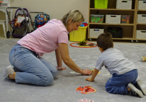 dzieci wkładają do buzi dinozaura odpowiednią ilość pokarmu
