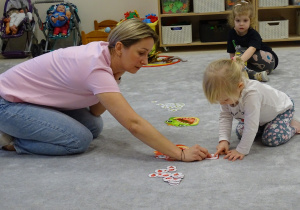 dzieci wkładają do buzi dinozaura odpowiednią ilość pokarmu