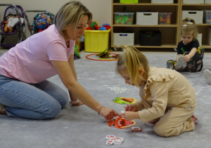 dzieci wkładają do buzi dinozaura odpowiednią ilość pokarmu