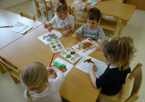 dzieci malują dinozaura farbami