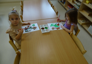 dzieci malują dinozaura farbami