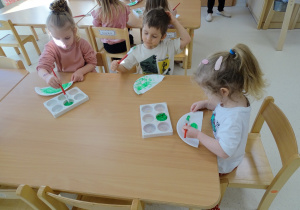 dzieci malują talerzyk farbami