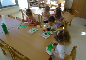 dzieci malują talerzyk farbami