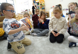 10 Chłopiec pokazuje dzieciom obrazek