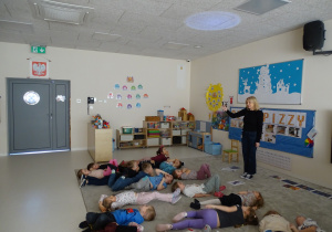 11 Dzieci leżą na dywanie i patrzą na światełko z latarki