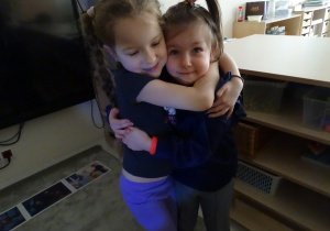 16 Dziewczynki się przytulają pokonując emocję strachu przed wyobrażoną trudną sytuacją